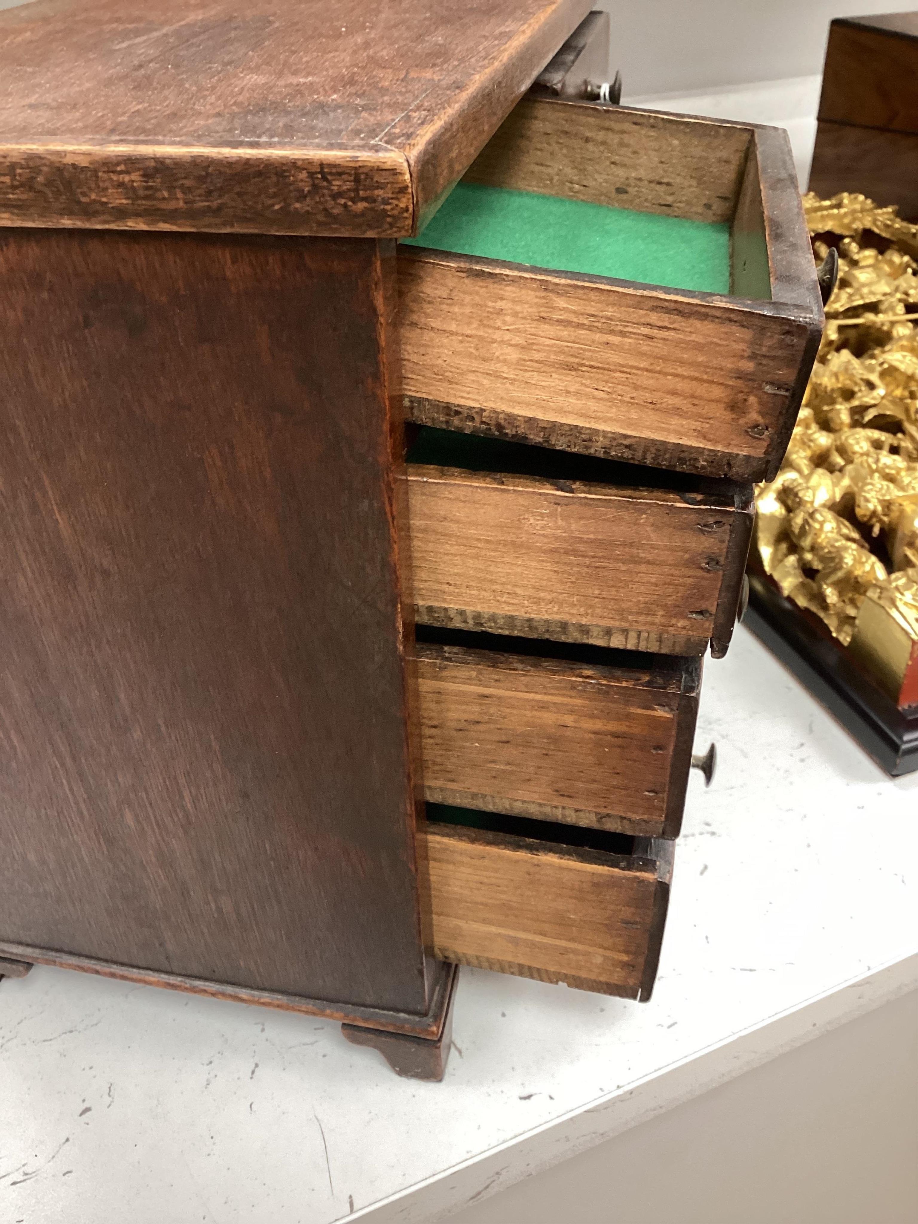 A miniature mahogany three long, two short, chest of drawers 32cms wide. Condition - good